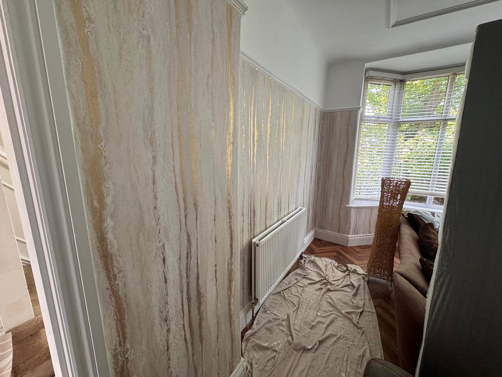 Bay window room papered in a marbled vertical pattern