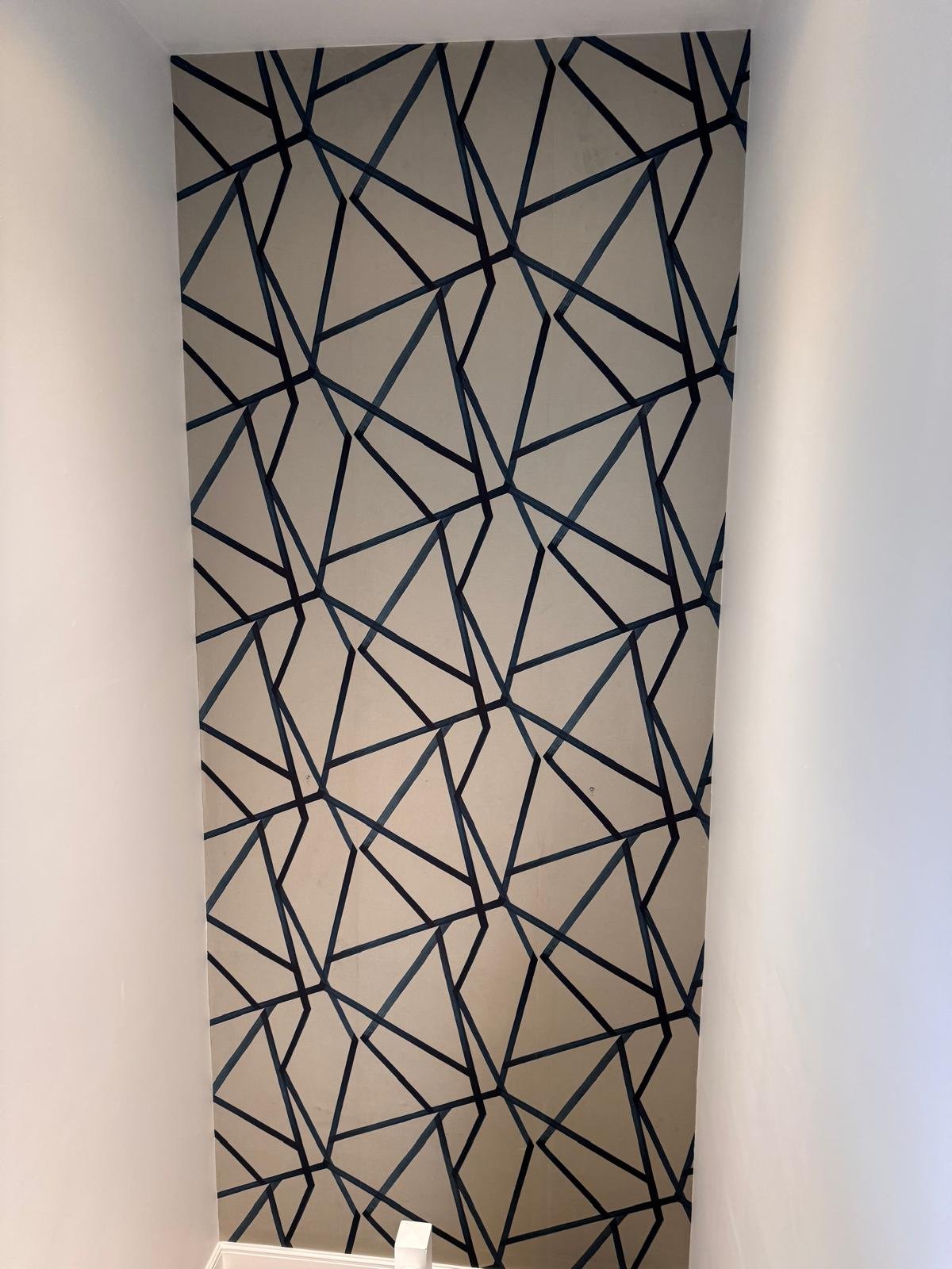 Feature wall in a navy and cream geometric wallpaper