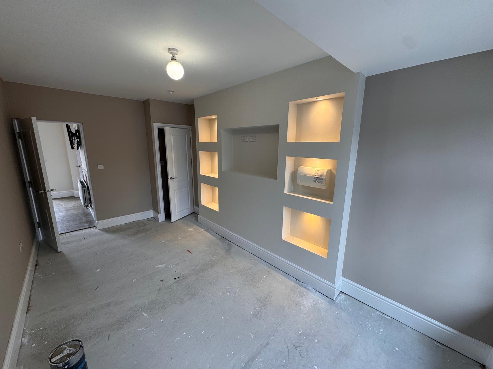 Room mid decoration with grey walls and lit alcove shelving