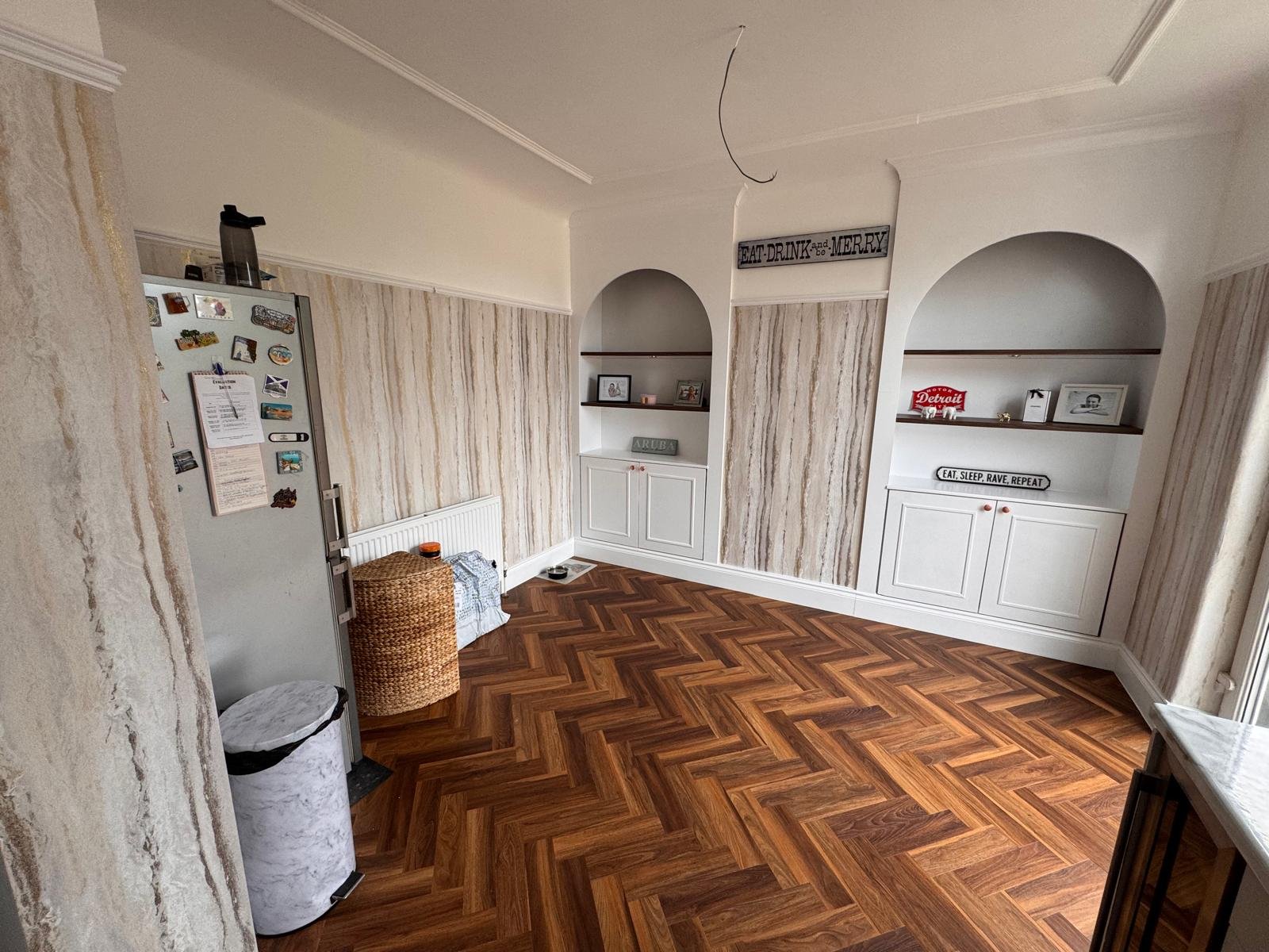Kitchen dining area with arched alcoves, textured wallpaper and herringbone flooring