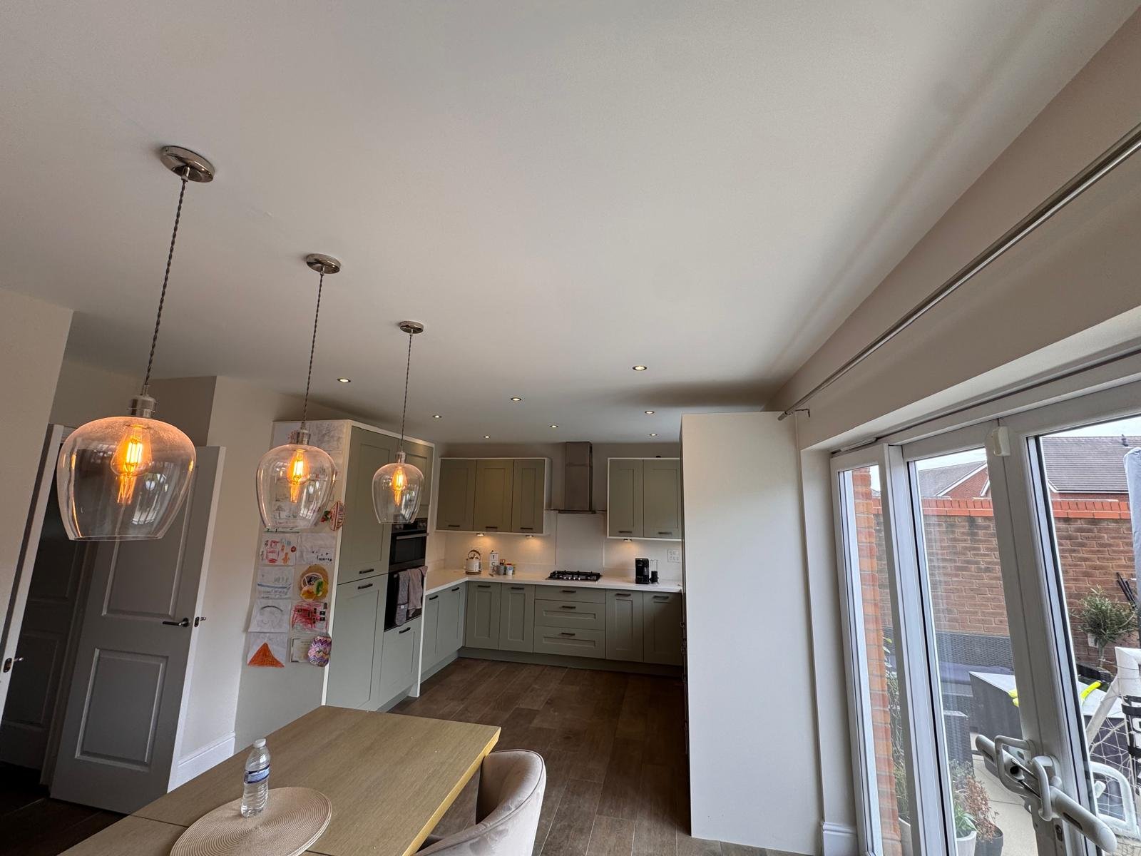 Kitchen diner with pendant lighting and garden doors