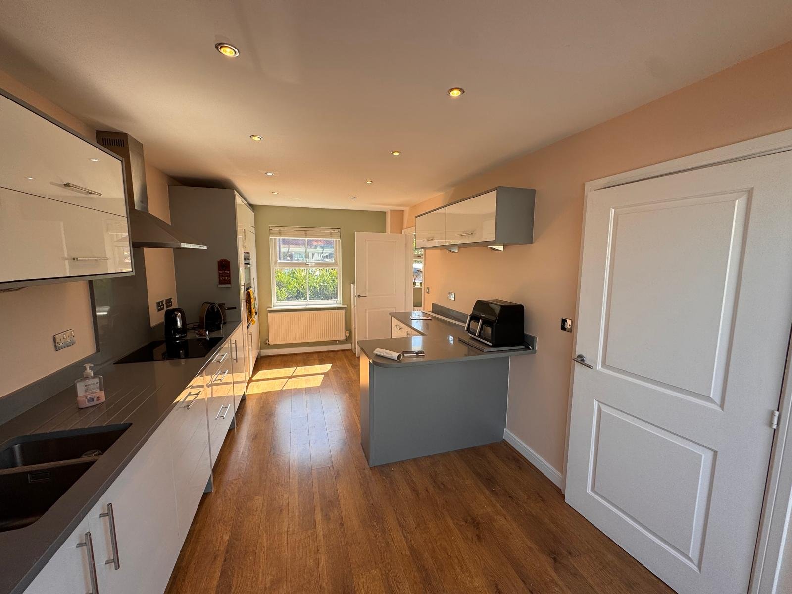 Galley kitchen with warm painted walls and a white door