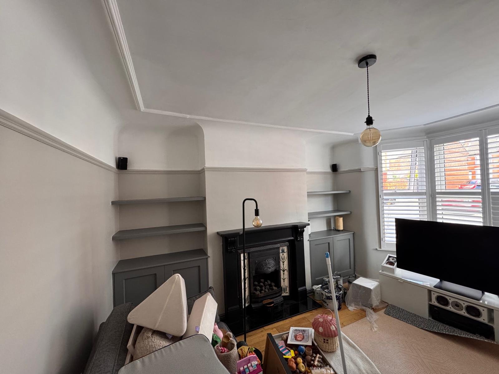 Living room with grey walls, alcove shelving and a log burner