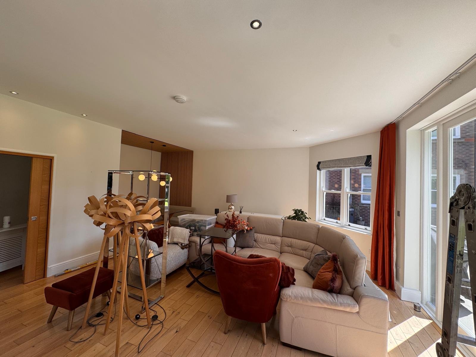 Open plan living room with neutral walls and a corner sofa