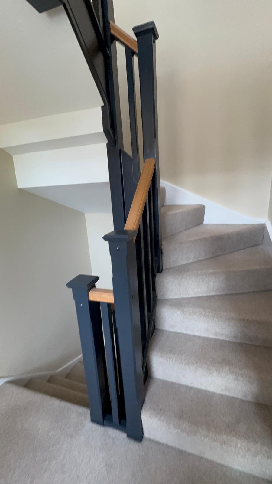 Staircase with navy spindles, newel post and timber handrail